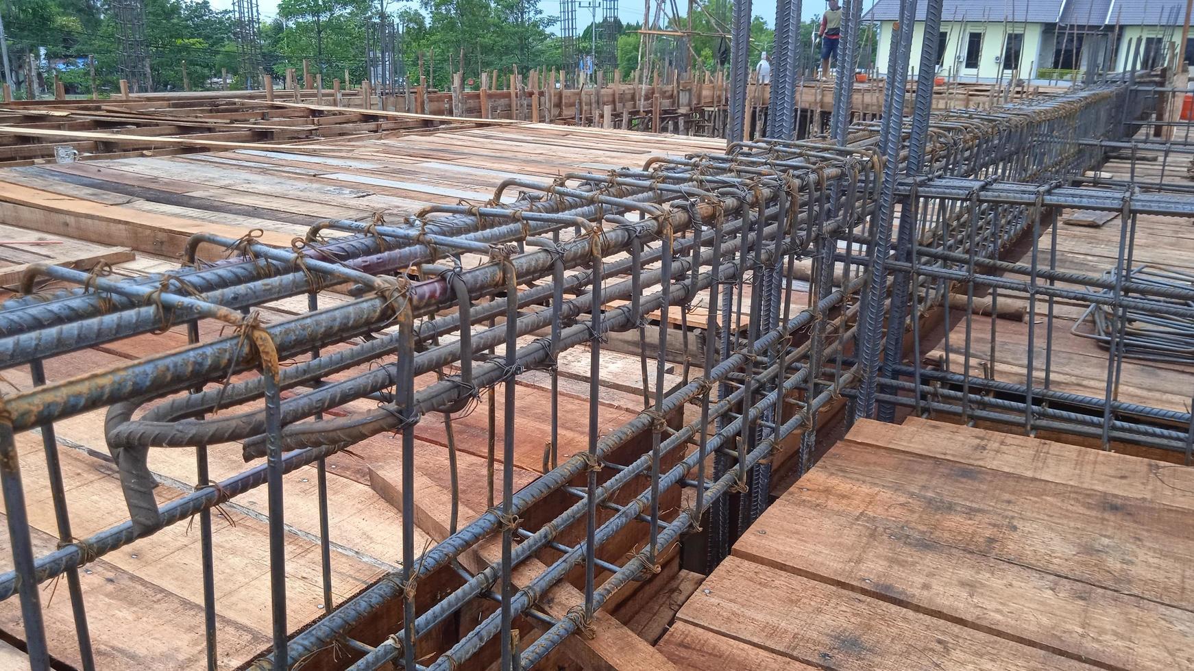 Construction worker stringing reinforcing steel rods at construction site. photo