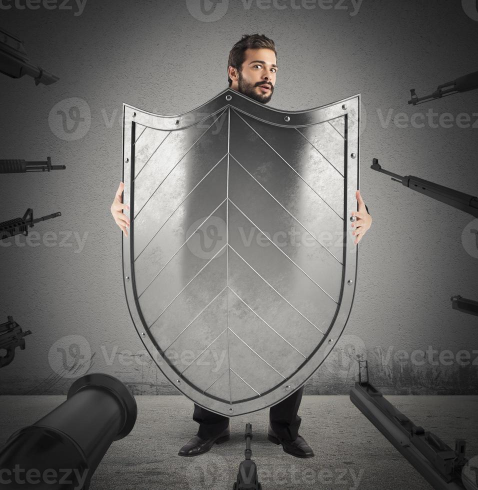 Frightened man behind a shield photo