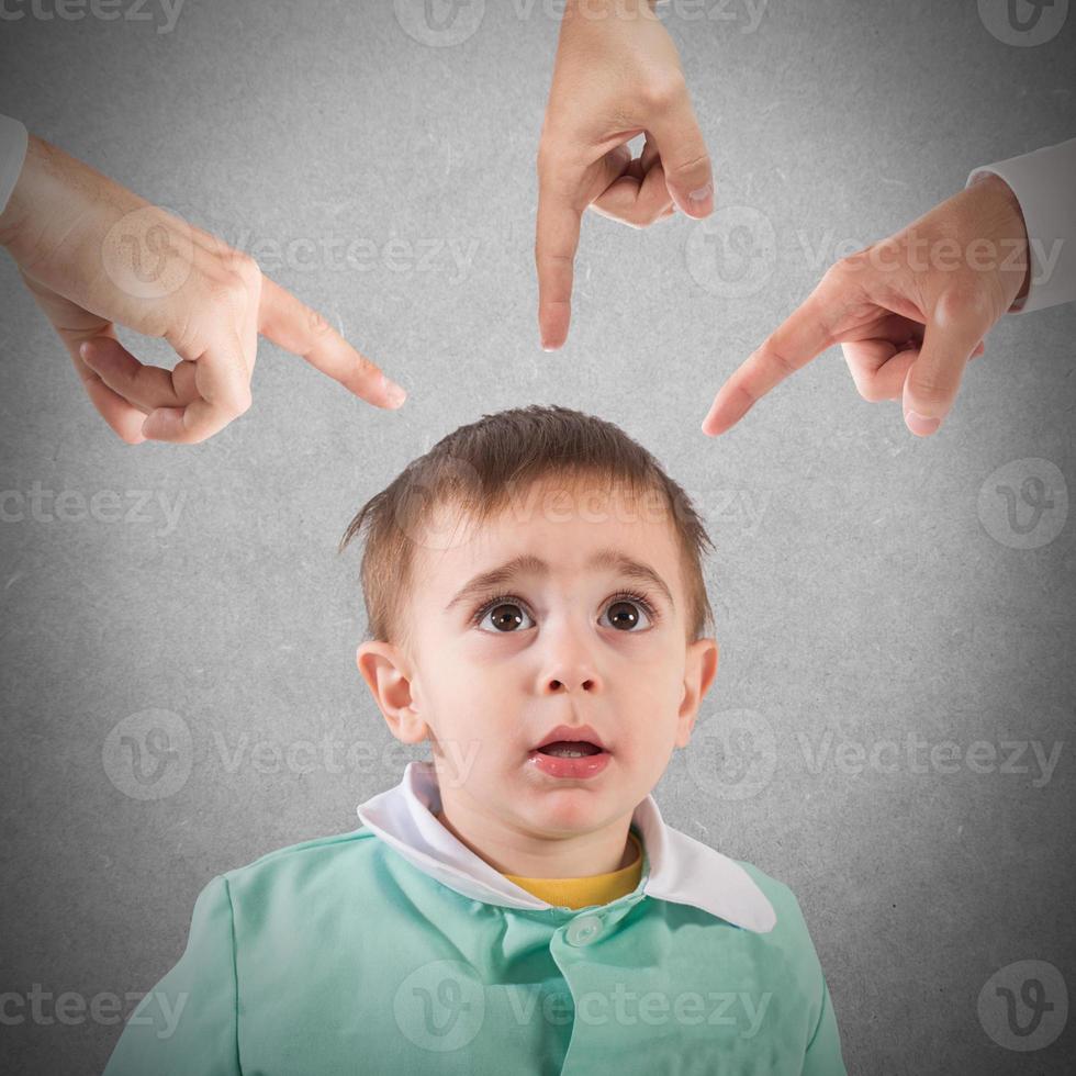 Reprimanded child with fingers pointing photo