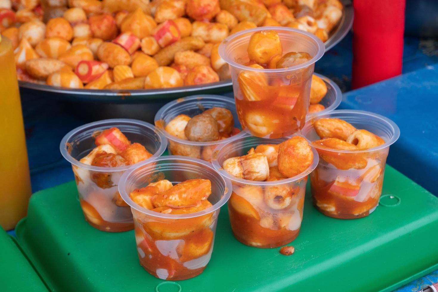 Fish meatballs served in plastic cups and sold at culinary festivals, traditional market snacks. Japanese food is called chikuwa photo