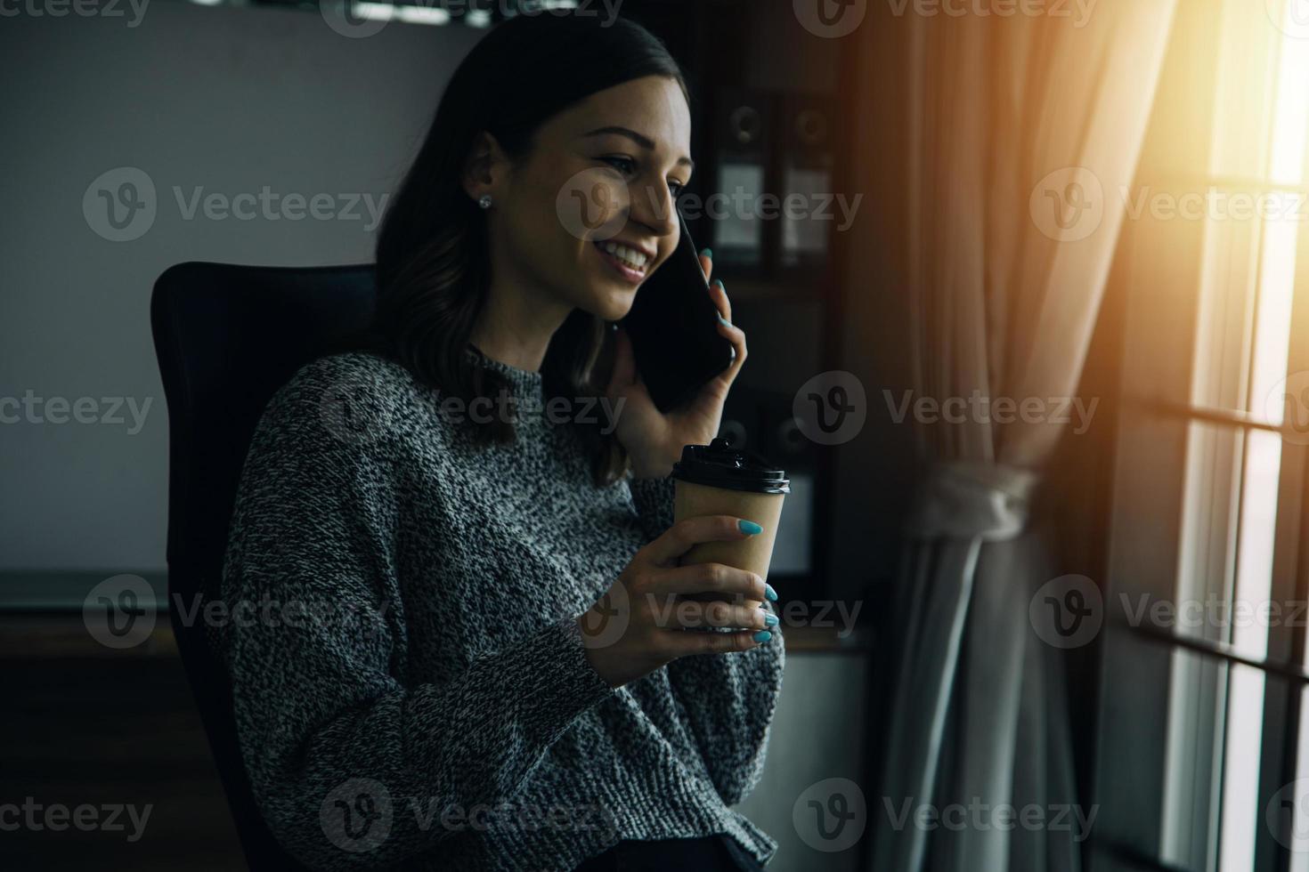 Young adult happy smiling Hispanic Asian student wearing headphones talking on online chat meeting using laptop in university campus or at virtual office. College female student learning remotely. photo