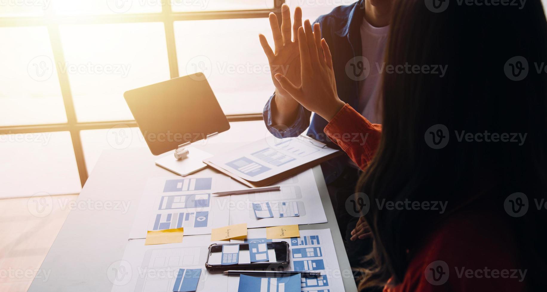 Close up ux developer and ui designer brainstorming about mobile app interface wireframe design on table with customer breif and color code at modern office.Creative digital development agency photo