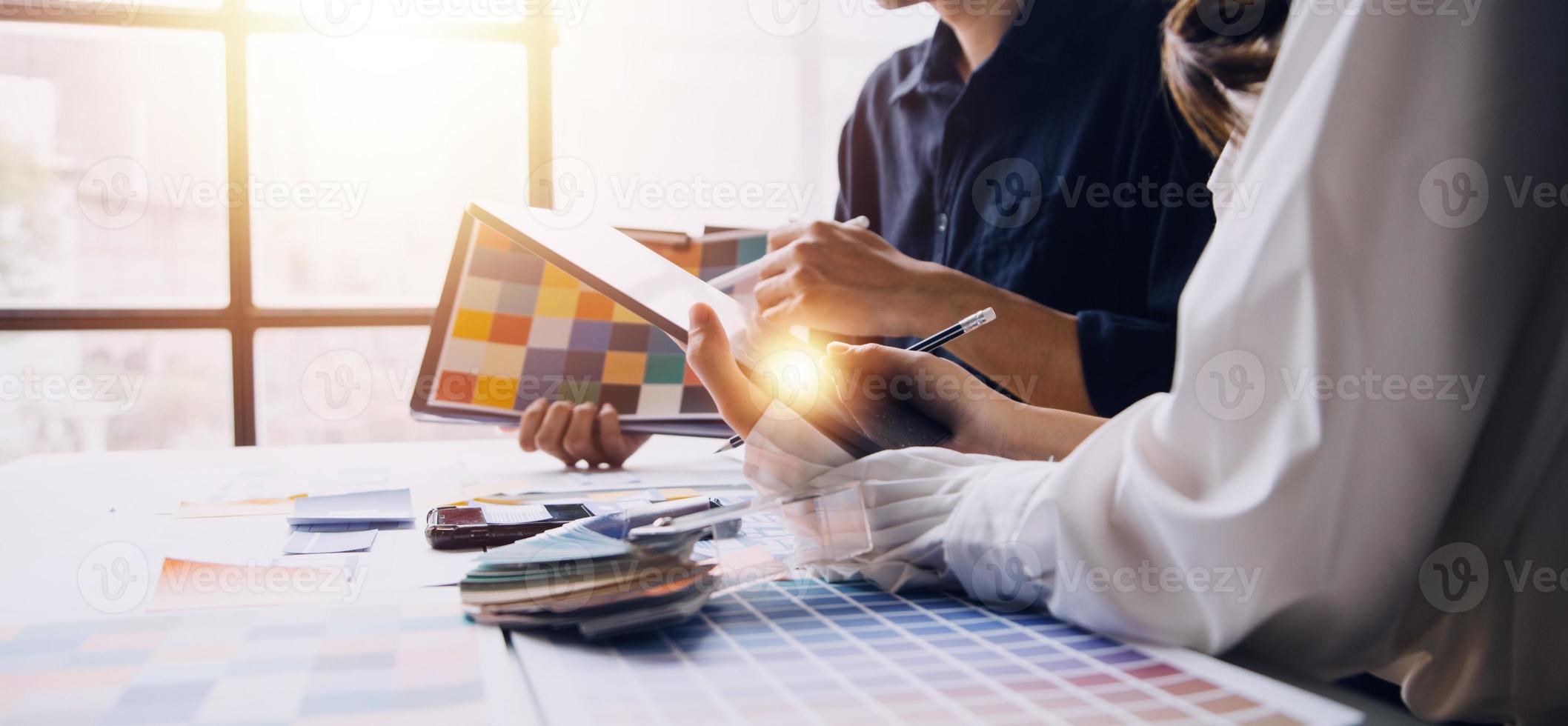 Close up ux developer and ui designer brainstorming about mobile app interface wireframe design on table with customer breif and color code at modern office.Creative digital development agency photo