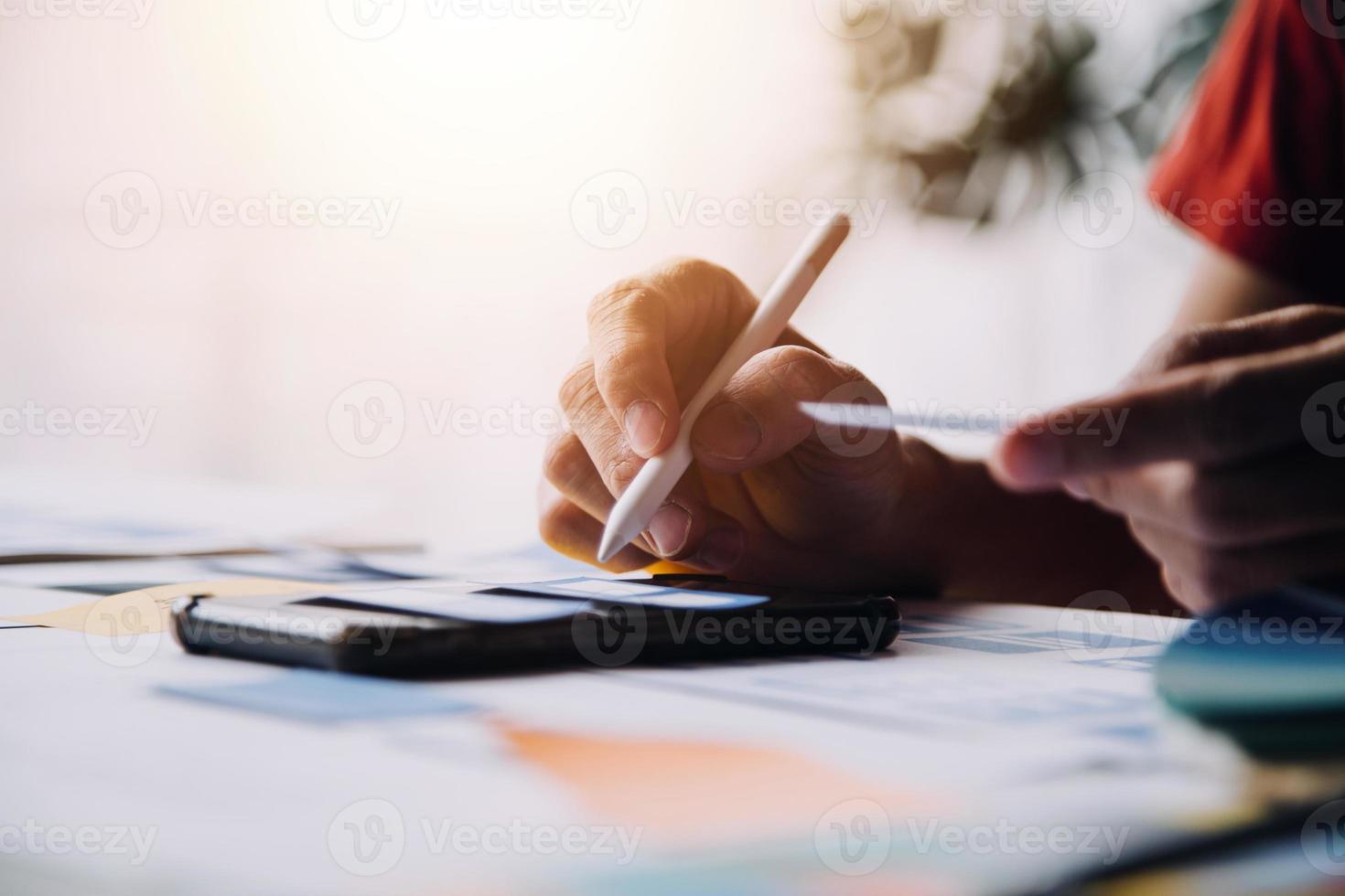 Close up ux developer and ui designer brainstorming about mobile app interface wireframe design on table with customer breif and color code at modern office.Creative digital development agency photo