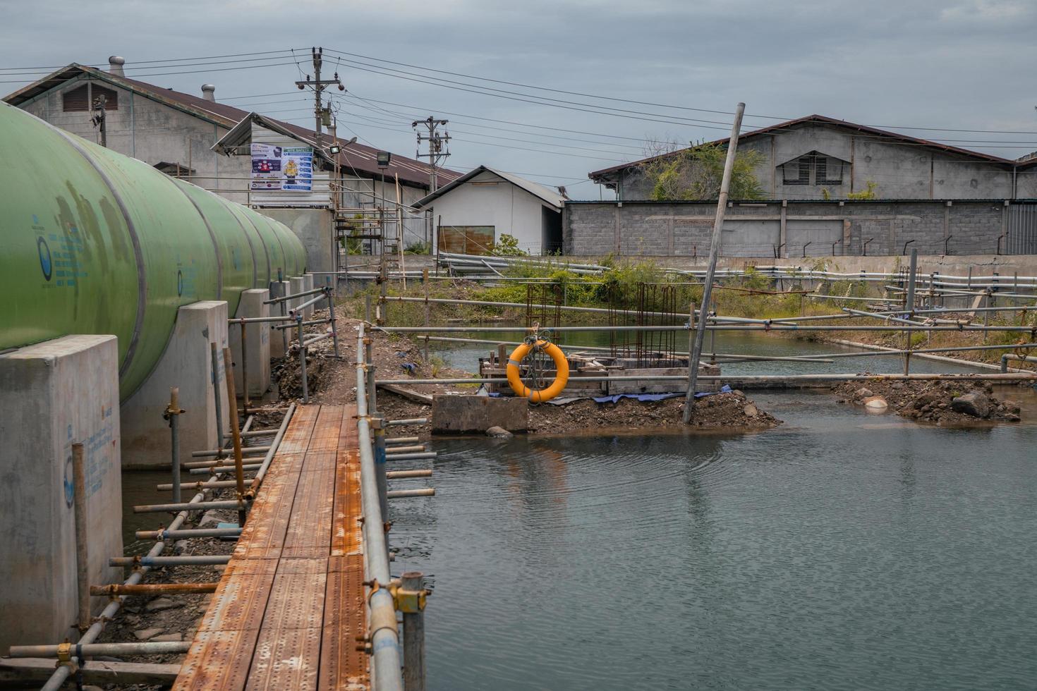 el temporal camino en el proyecto, cerca el agua estanque. el foto es adecuado a utilizar para industria antecedentes fotografía, poder planta póster y electricidad contenido medios de comunicación.