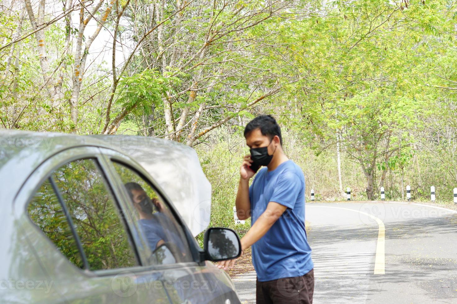 hombre llamado un mecánico a ven Mira a el roto coche. foto