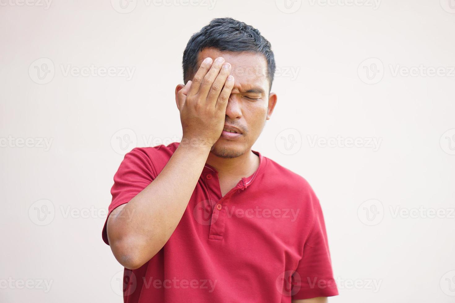 Asian man has eyestrain from looking at the computer photo