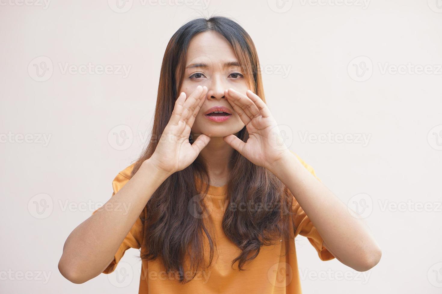 Asian woman whispering with her hand covering her voice photo