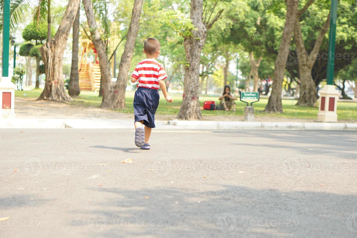 un chico corriendo en el calle en el parque foto