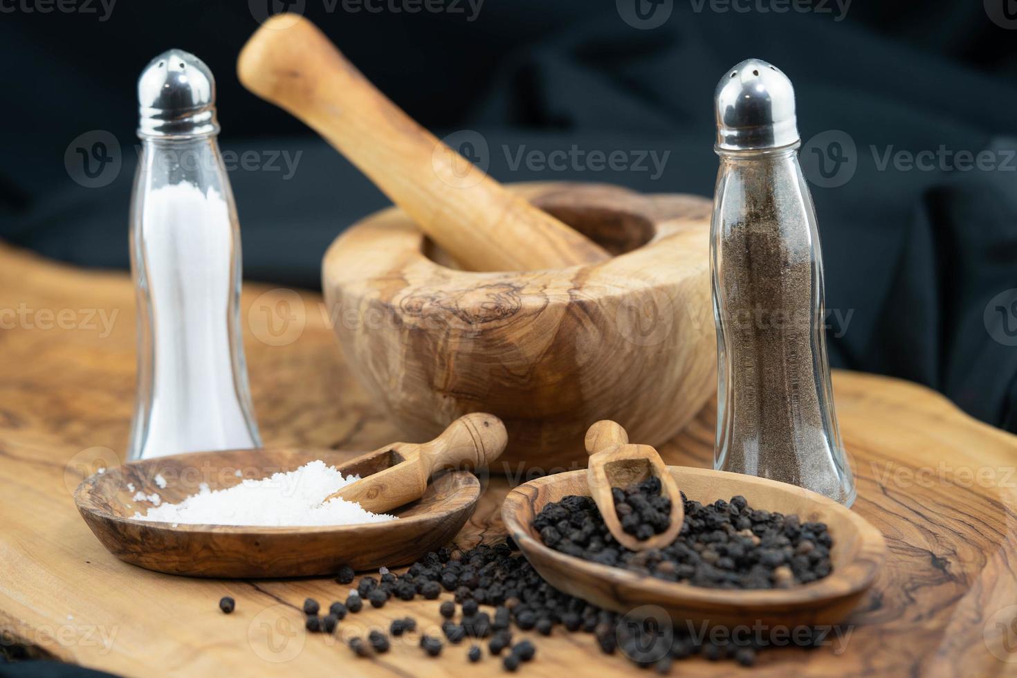 many black peppercorns on olive wood photo