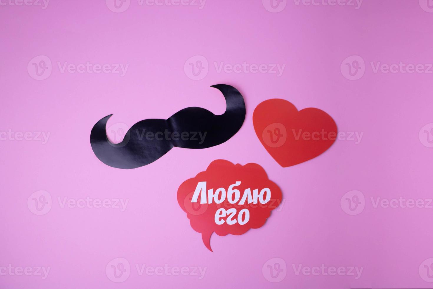 On a pink background paper black mustache red heart, cloud with the words I love him photo