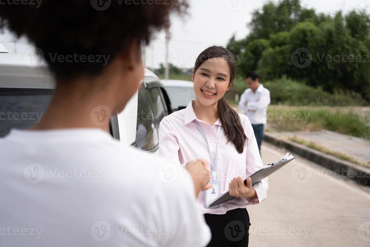 Women drivers Talk to Insurance Agent for examining damaged car and customer checks on the report claim form after an accident. Concept of insurance, advice auto repair shop and car traffic accidents. photo