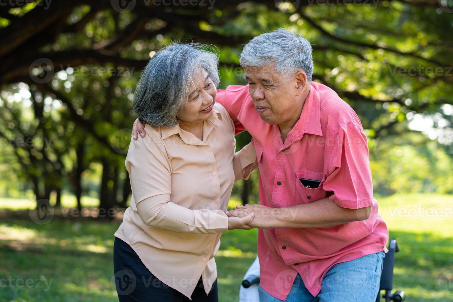 Asian senior man falling down on lying floor at park after Stumbled  and Crying in pain and him wife came to help support. Concept of old elderly insurance and health care photo