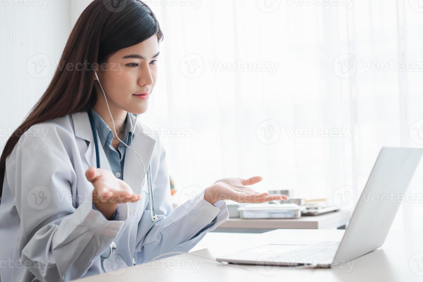 La doctora terapeuta asiática está visitando en línea a un paciente en la aplicación de Internet. ella escucha y da consejos y explica cómo tratar la enfermedad inicial, concepto de tecnología médica. foto