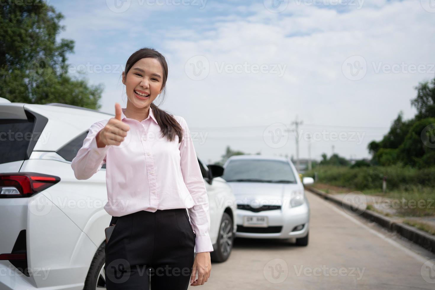 las mujeres conductoras se paran frente a los autos después de un accidente y no se preocupan porque tienen seguro contra accidentes automovilísticos. idea de reclamo de seguro de accidente automovilístico en línea después de enviar fotos y evidencia a un seguro.