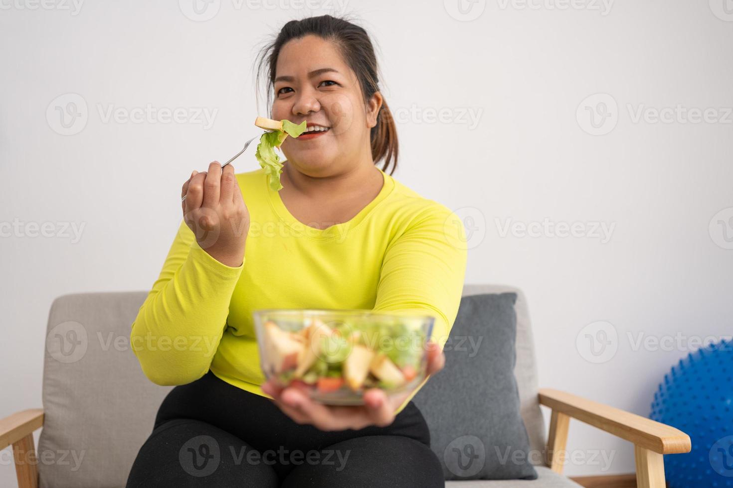 Asian Pregnant learn how to cook healthy meals from the Internet in kitchen, Fat women prepare a vegetable salad for diet food and lose weight. Concept of healthy eating photo