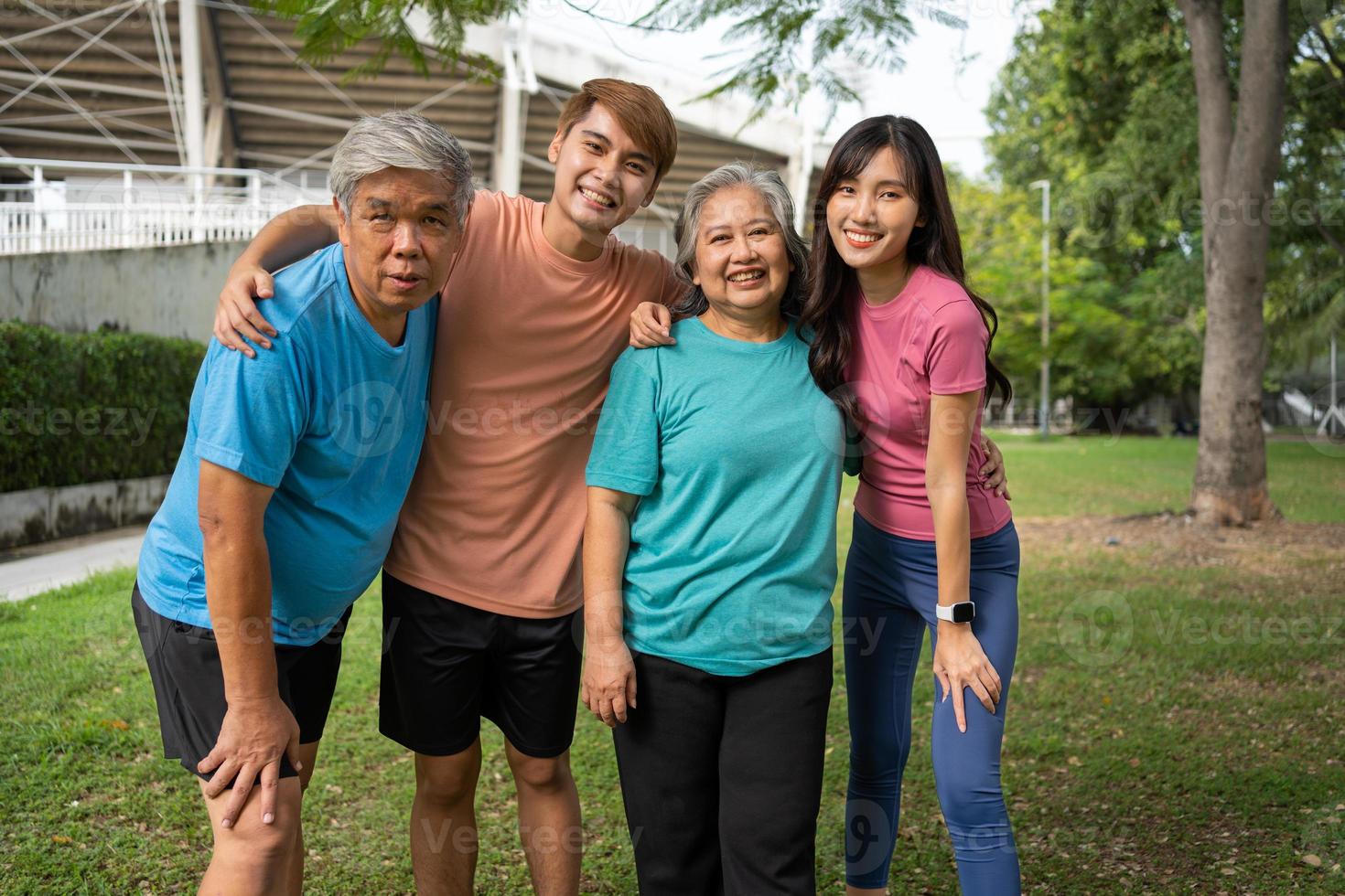 Healthy family group instructors workout in fresh air, and they rest and stand together after morning exercises in park. Outdoor activities, healthy lifestyle, strong bodies, fit figures, health care. photo