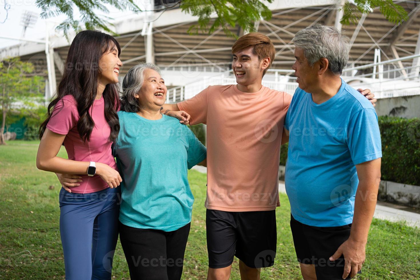 Healthy family group instructors workout in fresh air, and they rest and stand together after morning exercises in park. Outdoor activities, healthy lifestyle, strong bodies, fit figures, health care. photo