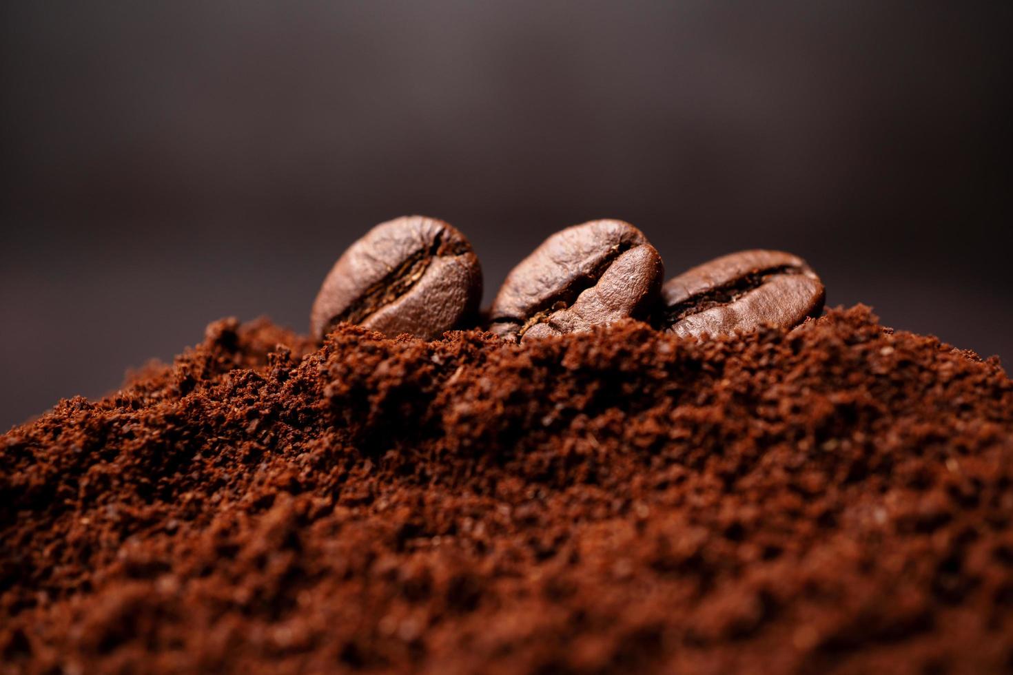 primer plano de tres granos de café en el montón mixto de café tostado con espacio para copiar texto. concepto de frescura del café foto