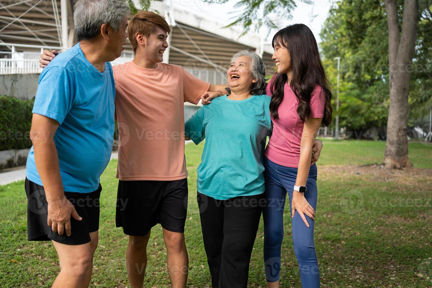 Healthy family group instructors workout in fresh air, and they rest and stand together after morning exercises in park. Outdoor activities, healthy lifestyle, strong bodies, fit figures, health care. photo