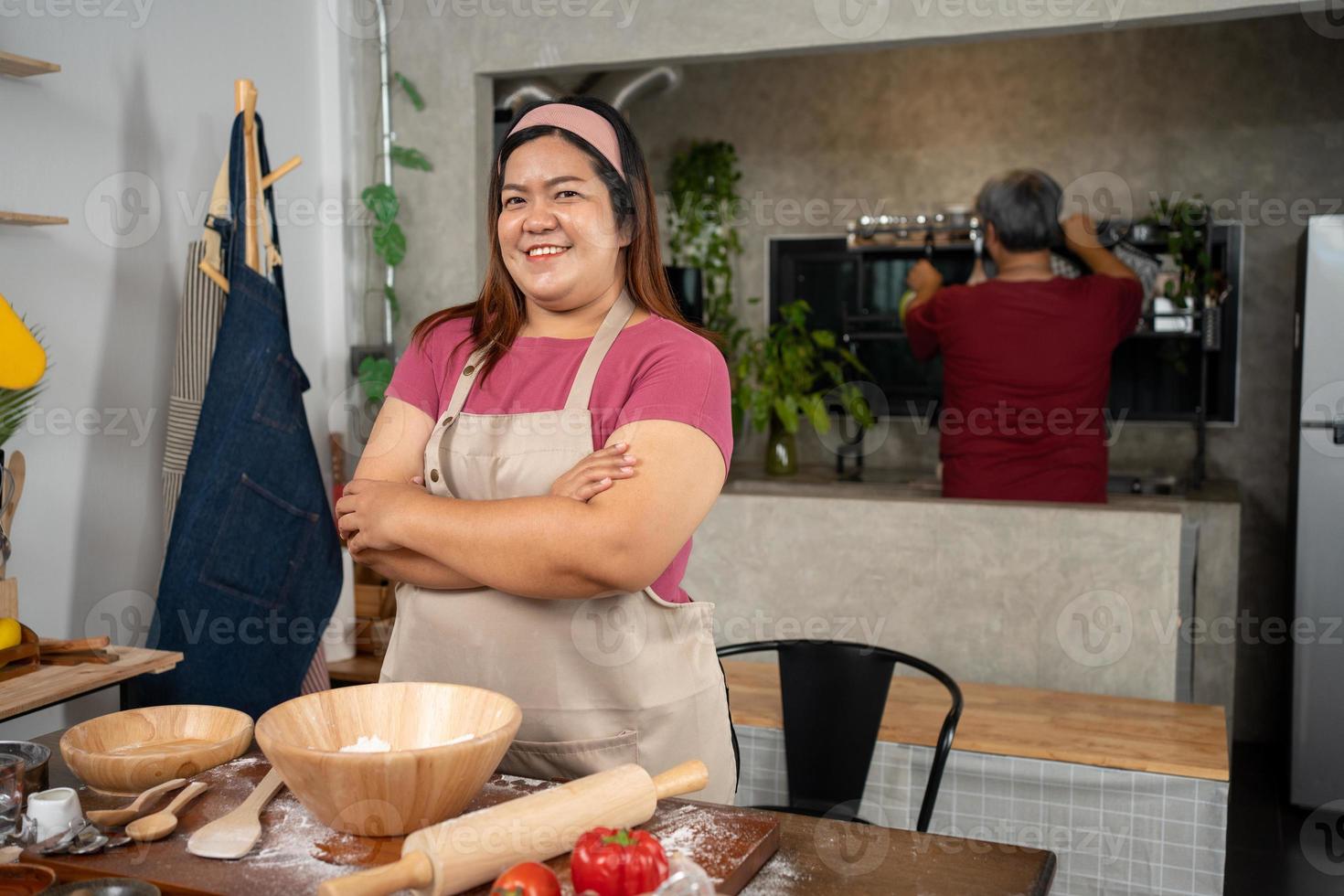 Portrait of obese woman cooking pizza in the kitchen, Raw pizza in the hands of a housewife. Homemade pizza cooking in the kitchen at home. Learning how to make yummy pizza dinner lunch photo