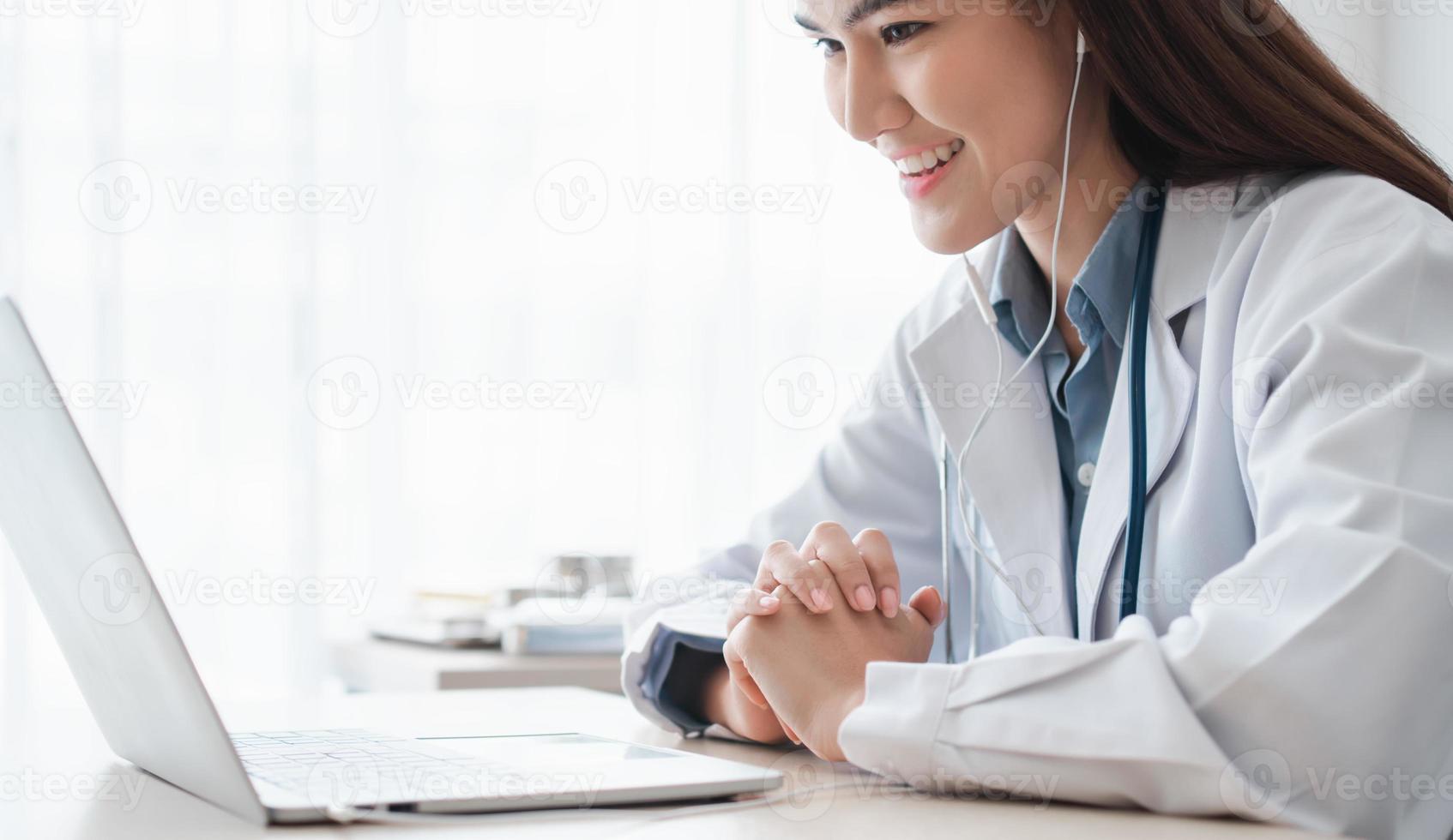 una doctora asiática está visitando en línea a un paciente en la aplicación de Internet y escuchando los síntomas y explica cómo tratar la enfermedad inicial, concepto de tecnología médica. foto