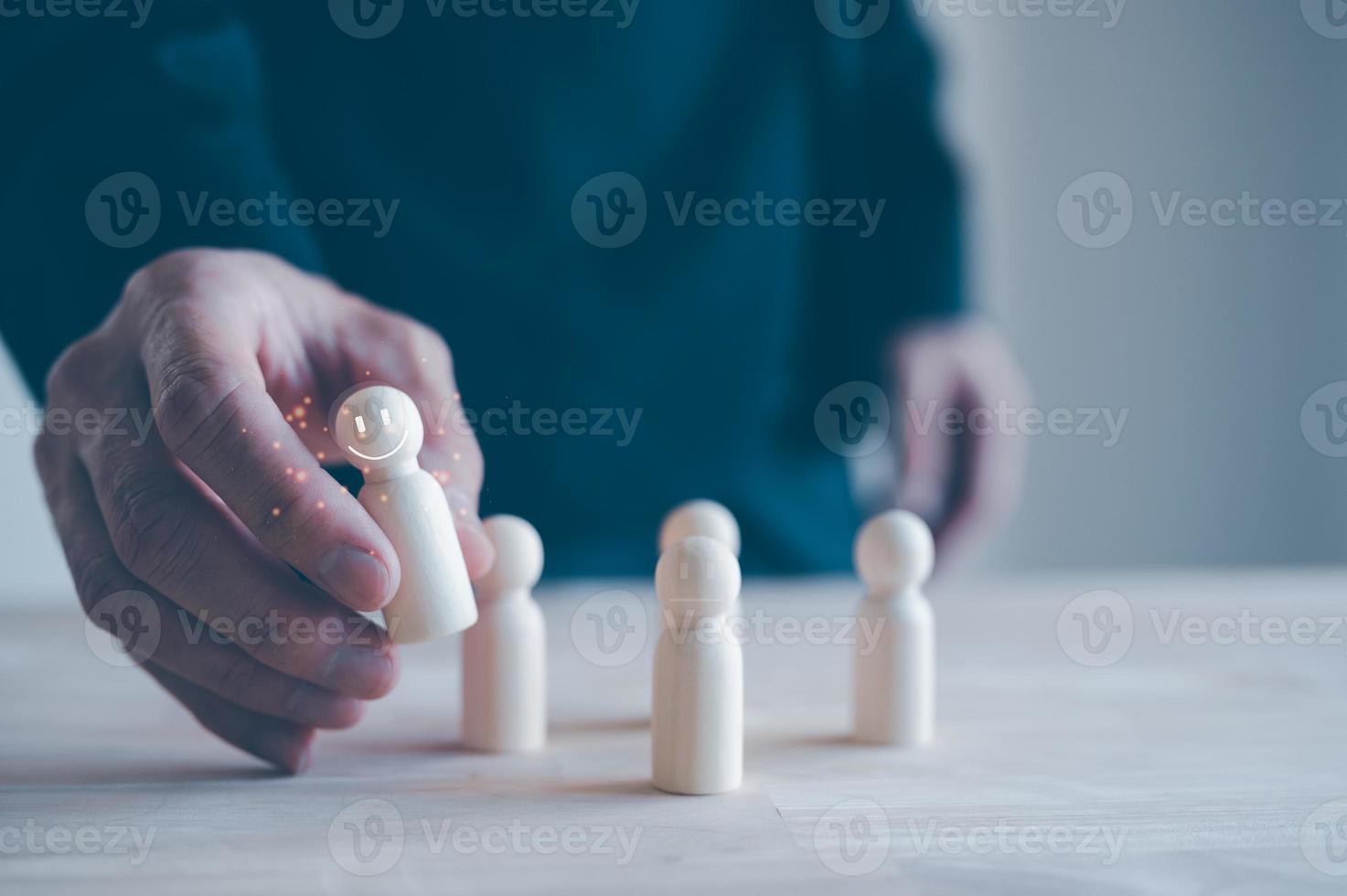 team leader hunter, man picking up wooden people from group of candidate or crowd, HR management recruiting team leader. recruitment agency photo