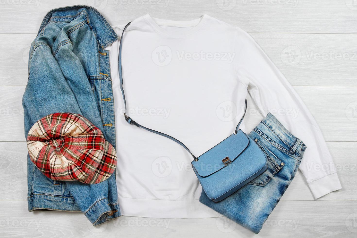 White Sweatshirt mockup. Template blank shirt top view on white wooden background. Winter outfit on wood floor. Woman fashion clothes. Spring look of today. Female Jeans, hat, bag accessories photo