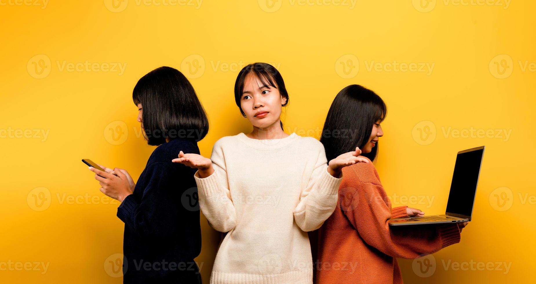 Two Asian women working on laptop and phone. at the same time Two of them were communicating online and showing happy smiles. and does not care about the people around him and his friends online photo
