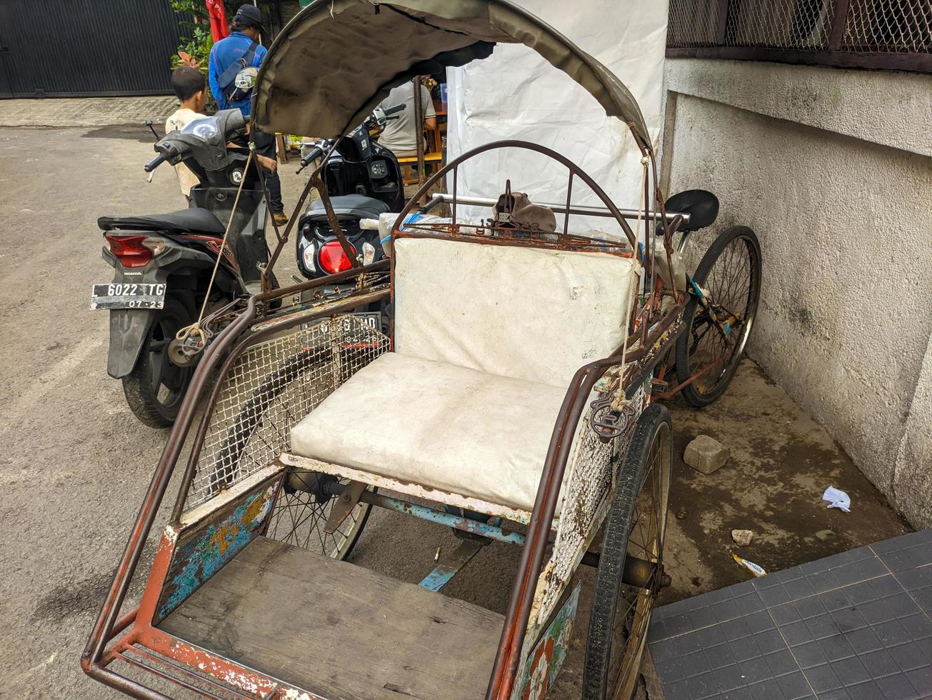 a close up of indonesian rickshaw or becak with white seat photo
