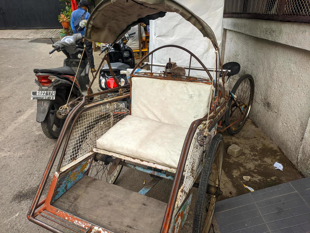 a close up of indonesian rickshaw or becak with white seat photo