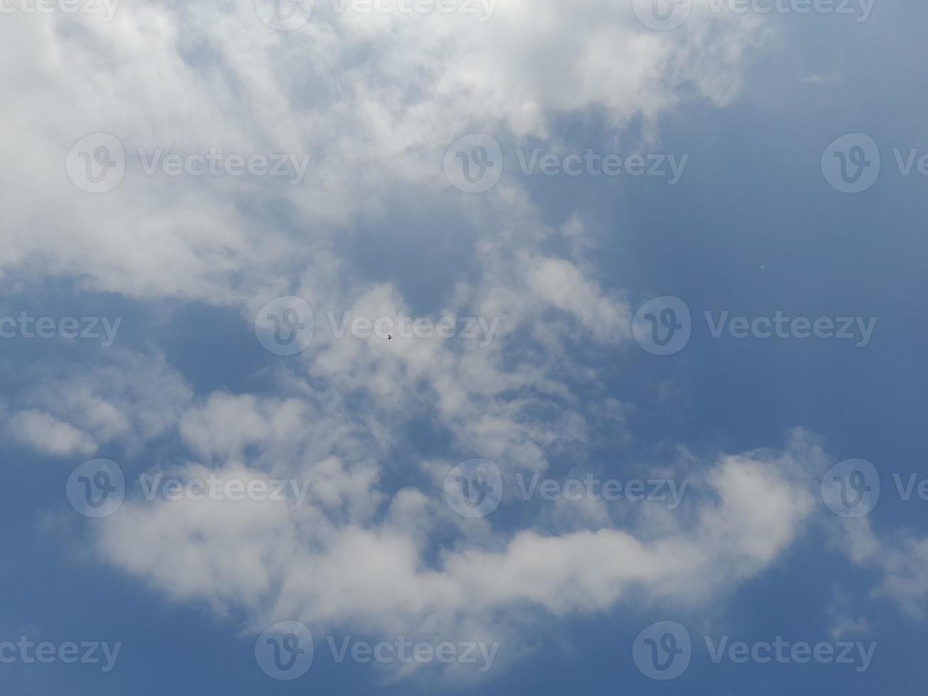 Beautiful white clouds on deep blue sky background. Large bright soft fluffy clouds are cover the entire blue sky. photo