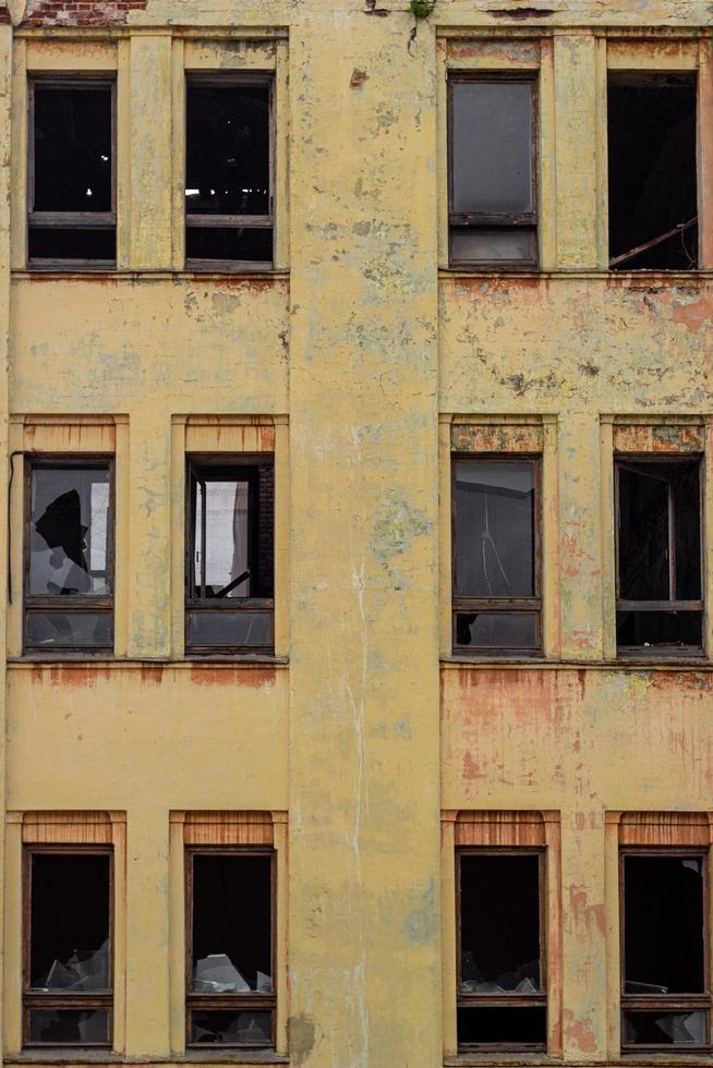 Broken windows in the old yellow house. photo