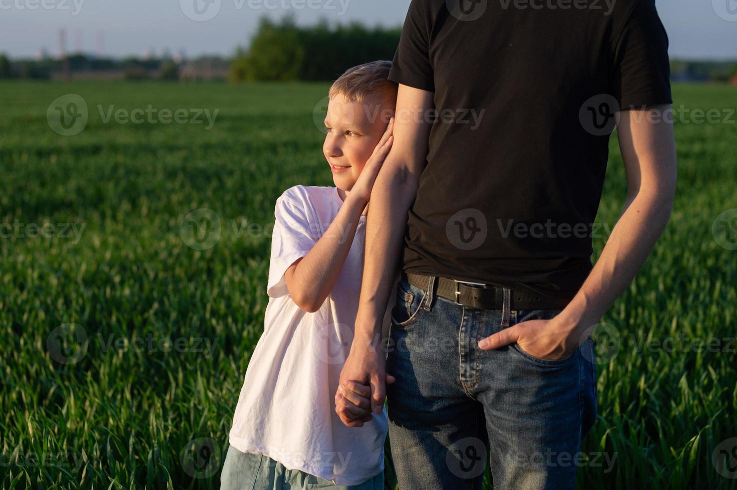 un linda niño sostiene su del padre mano y acurrucarse arriba a su. naturaleza caminar foto