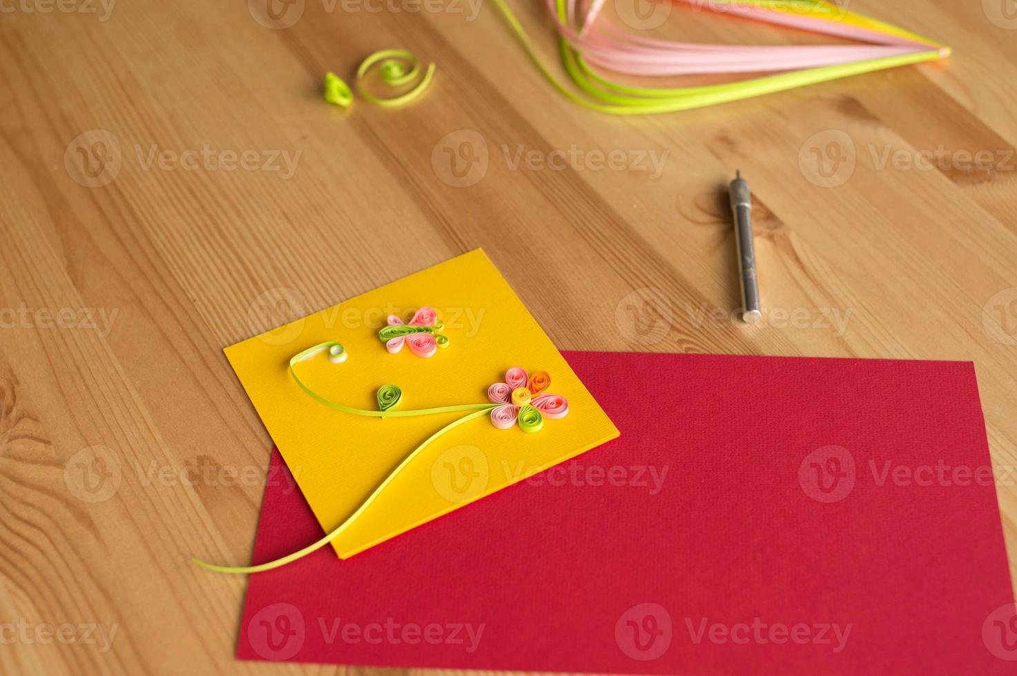 Making postcards from long and narrow strips of paper twisted into spirals, quilling photo