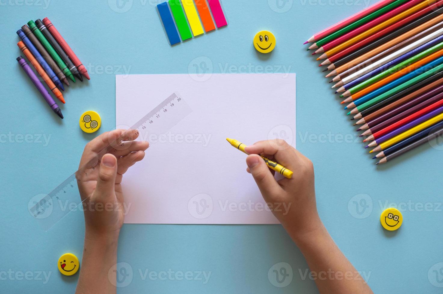A set of bright stationery on a blue background. Hands holding a ruler photo