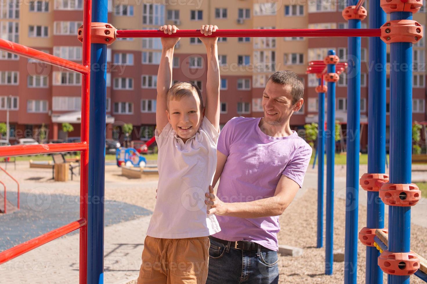 Cute baby and daddy play on the playground photo