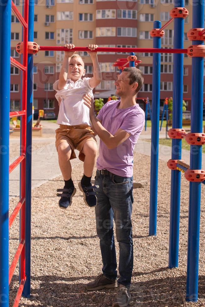 Cute baby and daddy play on the playground photo