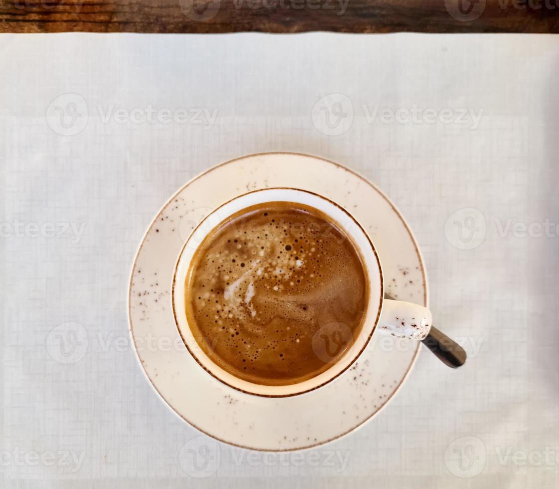 Top view of a cup of Cafe Crema on a white doily. photo