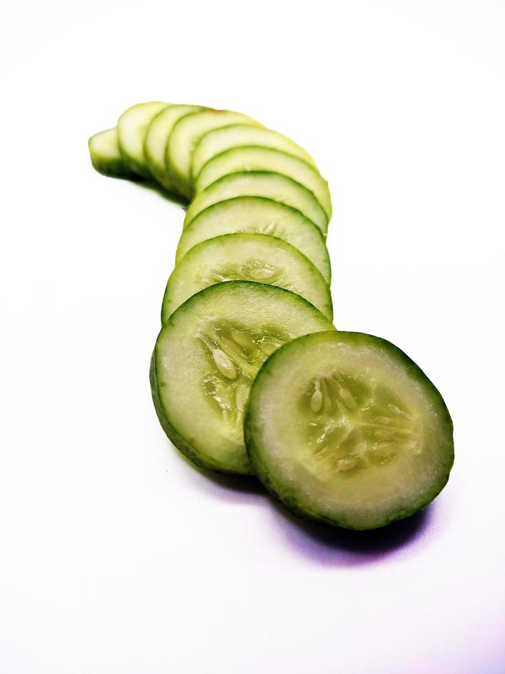 cucumber slices arranged parallel isolated in white background photo