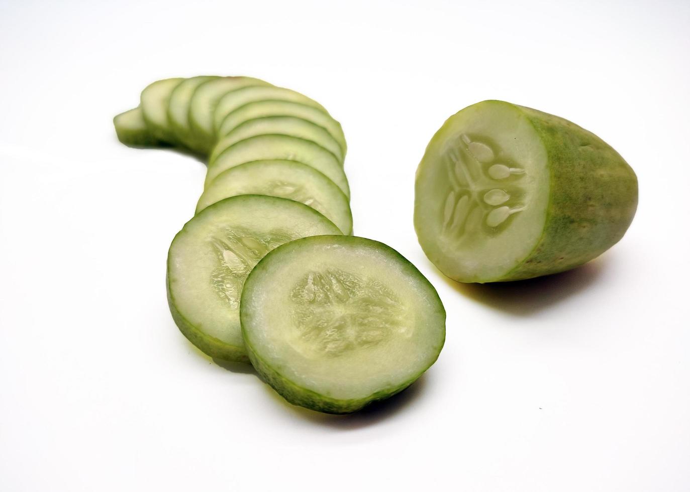 cucumber slices arranged parallel isolated in white background photo