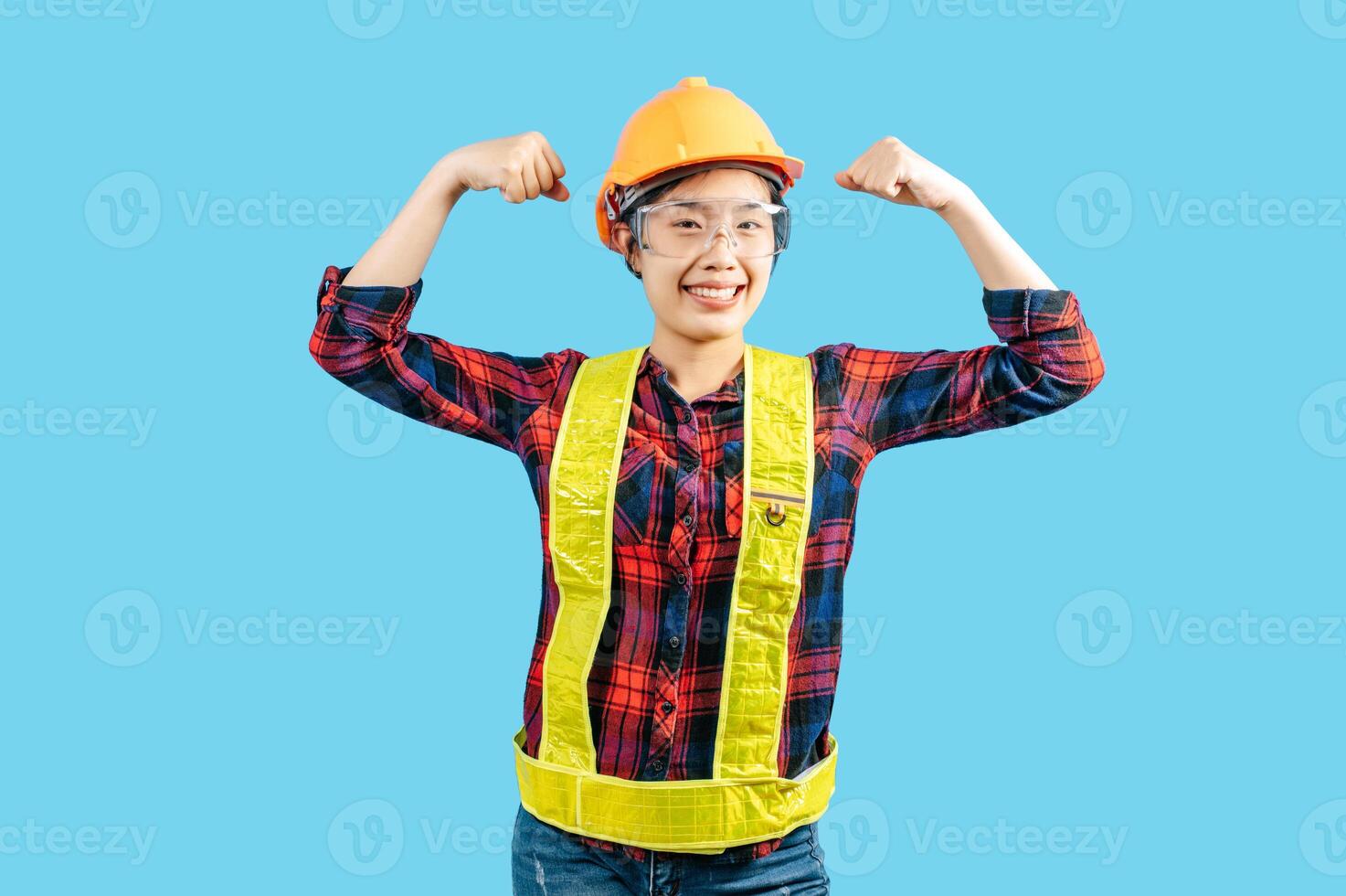 joven hembra ingeniero en casco estar con fuerte postura foto