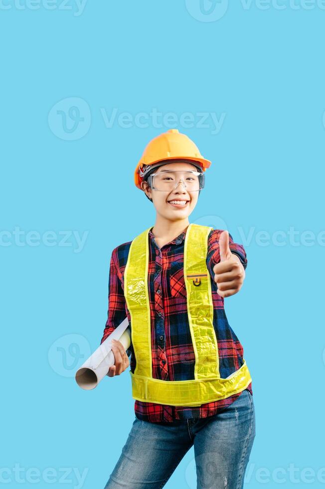 Young female engineer wearing yellow helmet hold blueprint posture photo