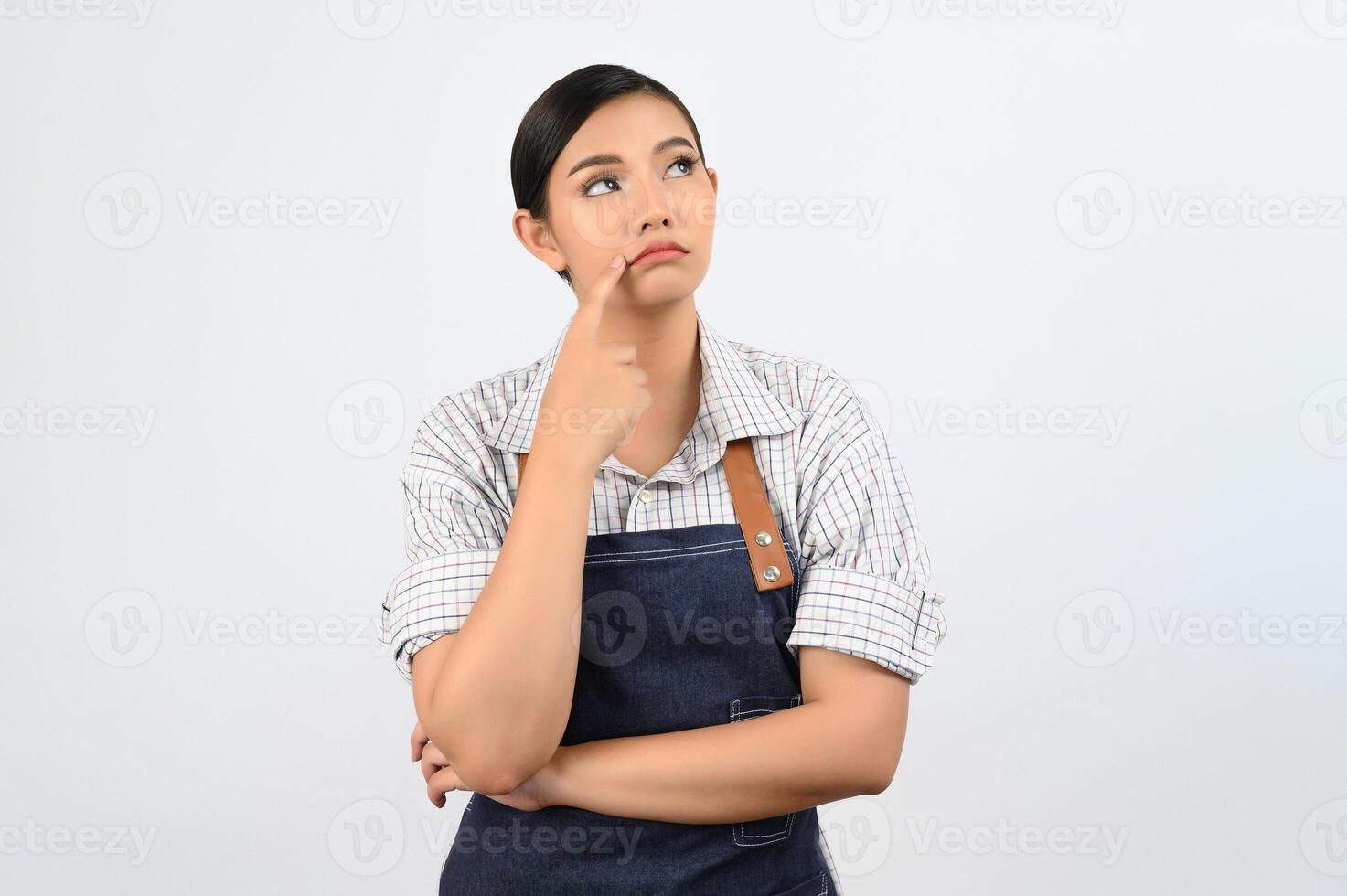 Portrait of thoughtful young asian woman in waitress costume ingenious poseture photo