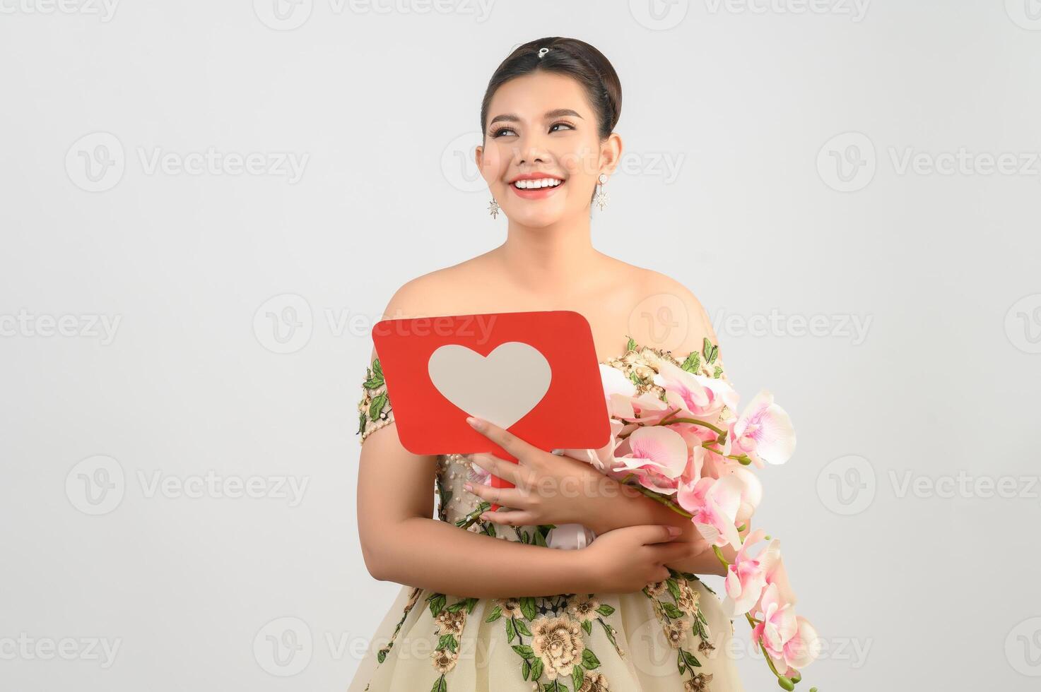 Asian beautiful bride smiling and posing with heart sign on white background photo