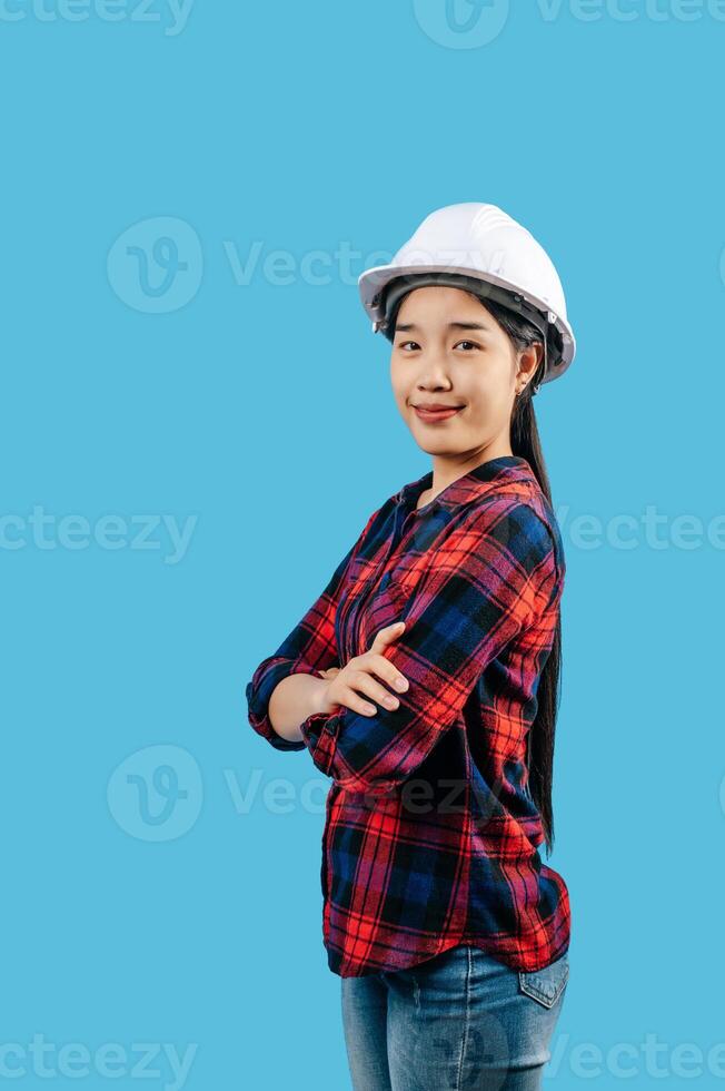 Young female engineer wearing yellow helmet stand with charming smile posture photo