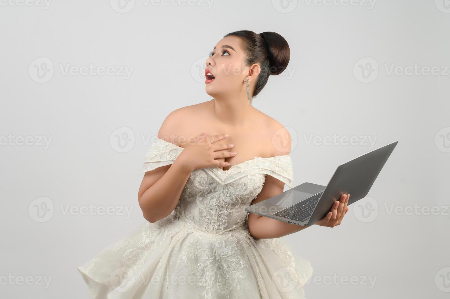 Young asian beautiful bride pose with laptop computer in hand photo