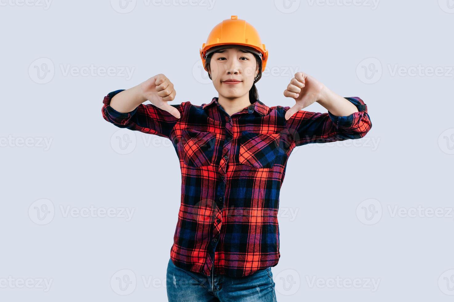 Young female engineer in helmet stand with thumb up posture photo