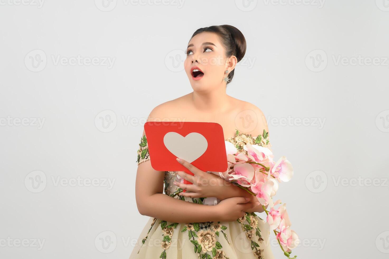 Asian beautiful bride smiling and posing with heart sign on white background photo