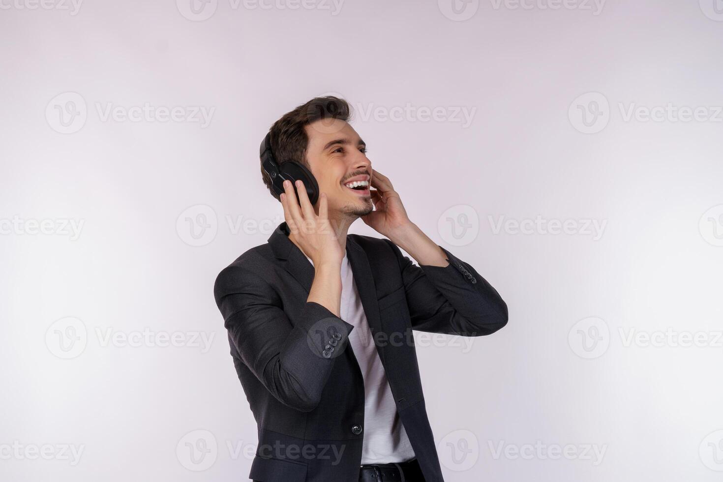 retrato de un joven feliz usando auriculares y disfrutando de la música sobre fondo blanco foto